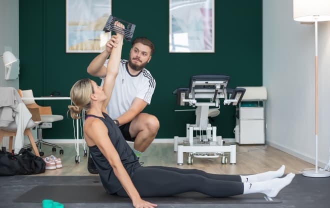 Physiotherapist Josh helping a client with her workout.